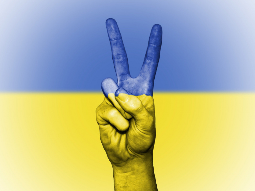 Flaga Ukrainy i dłoń w geście wiktorii