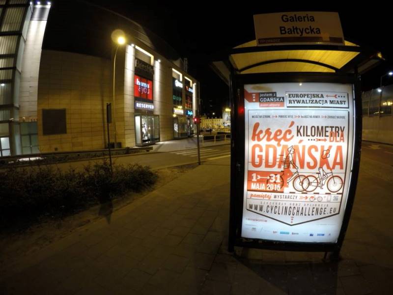 Przystanek autobusowy z plakatem reklamującym akcję Rowerem do pracy