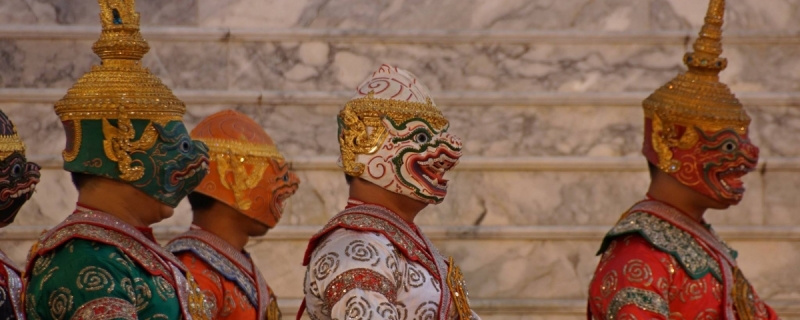 trzy osoby prawym profilem w tradycyjnych maskach