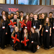 Zdjęcie grupowe uczestników Konferencji TEDxPolitechnika Gdańska 2025 na ściance zdjęciowej.