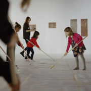 Zdjęcie dzieci rysujących kredą na patyku w trakcie warsztatów.