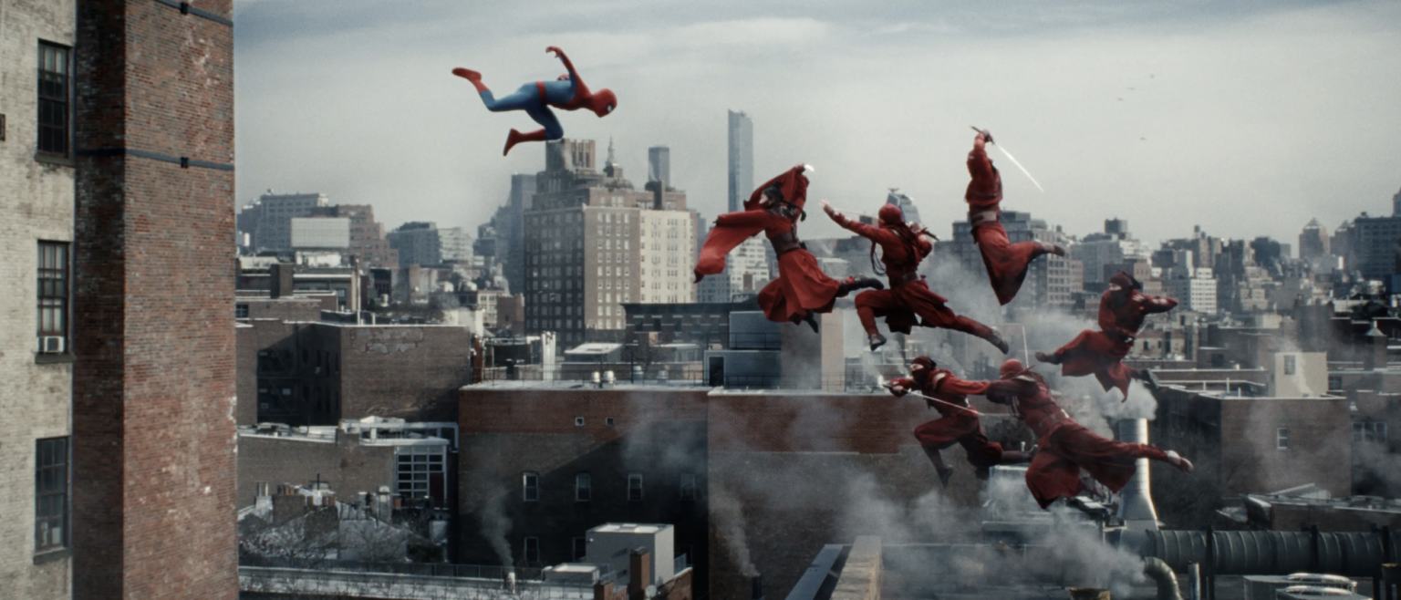 Spider-Man walczy w powietrzu z czerwonymi wojownikami. Kadr z filmu Spider-Man. Całkiem nowy dzień.