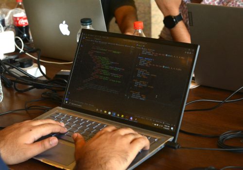 a man using a laptop computer on a wooden table