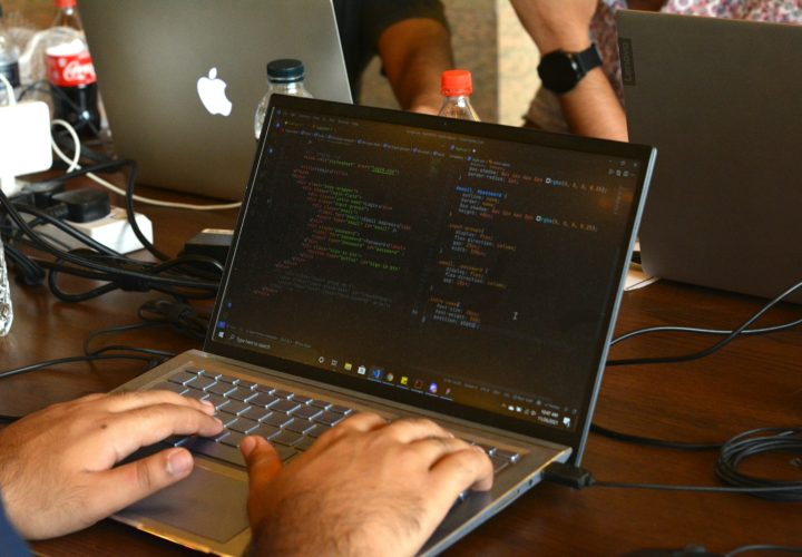 a man using a laptop computer on a wooden table
