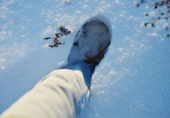 A boot stepping into fresh snow